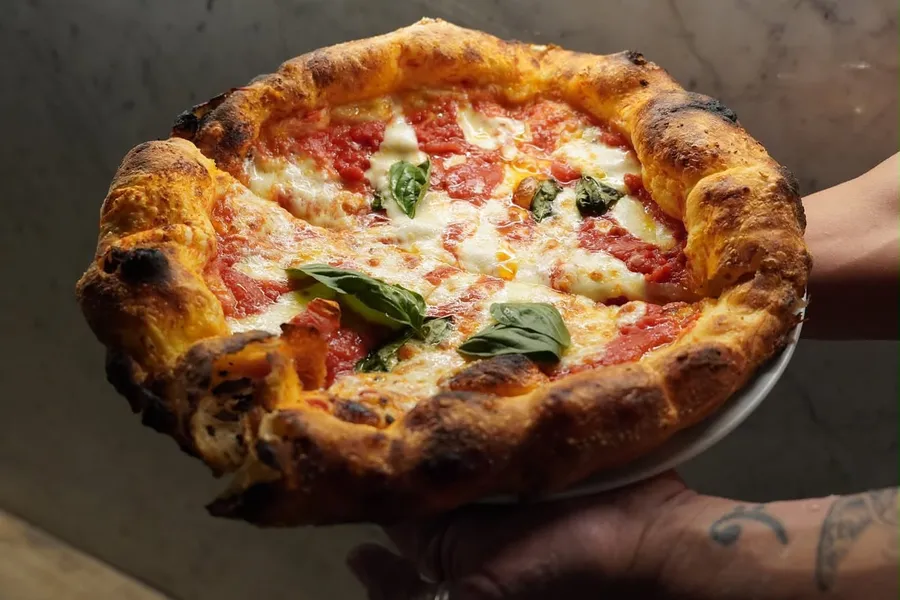 Margherita pizza with a puffy blistered crust, mozzarella and fresh basil, The Food Hub pizza catering Sydney