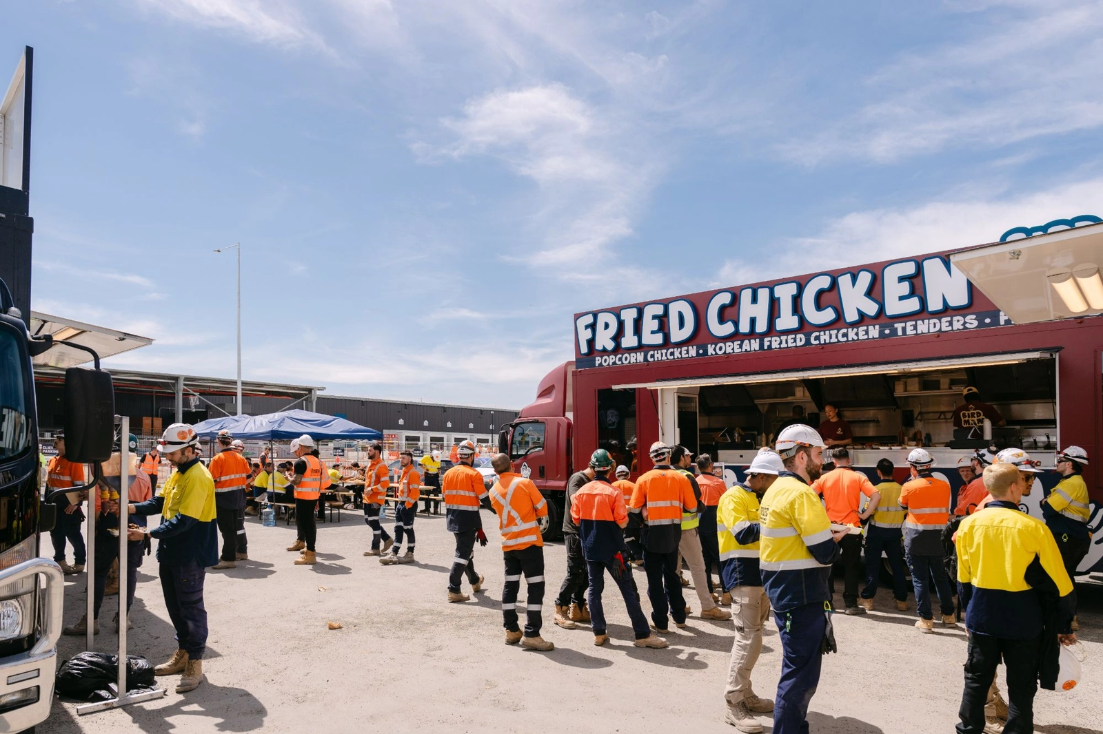 Construction workers in hi vis queuing at the Birdman fried chicken truck during the Vanderlande site lunch in Moorebank